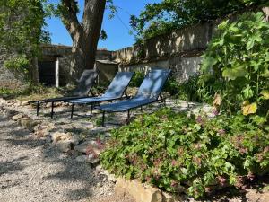 three chairs sitting in a garden with flowers at Le SAN - Chambre d'hôtes INCLUSIVE & ÉCORESPONSABLE in Beauchery