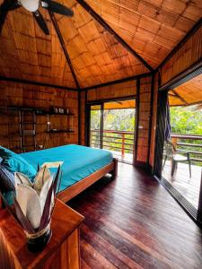 1 dormitorio con 1 cama en una habitación de madera en TREEHOUSE PILON PAVONES en Pavones