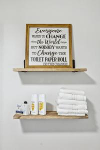a shelf with towels and a sign that reads everyone wants to change the world but at Large Private Studio Apartment in Lockport