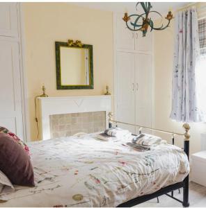 a white bedroom with a bed with a mirror and a mirror at Beach House in Whitley Bay