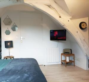 a bedroom with a bed and a tv on a wall at Studio cosy Rocherfort en Terre Centre in Rochefort-en-Terre