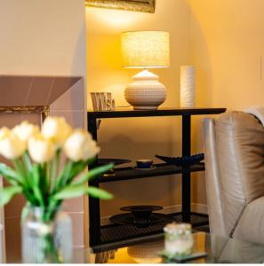 a living room with a table with a lamp and flowers at Beach House in Whitley Bay