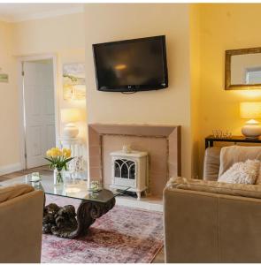 a living room with a fireplace and a tv on the wall at Beach House in Whitley Bay +14 photos