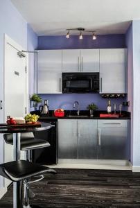 a kitchen with stainless steel appliances and a table at M HOTEL in Miami Beach