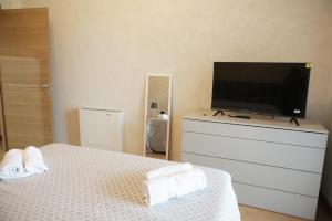 una camera con letto e TV a schermo piatto di unica affittacamere a Roma