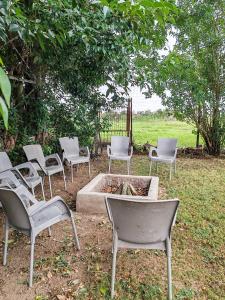 a group of chairs sitting around a fire pit at Claymore Country Cottage in Winterton