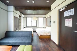 Kobe Motomachi Roji Building - Vacation STAY 16195 في كوبه: غرفة نوم بسرير واريكة في غرفة