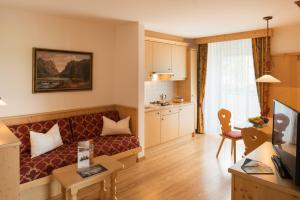 un soggiorno con divano e una cucina di Apparthotel Germania a Dobbiaco