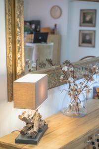 a table with a mirror and a vase with flowers at Konak Lecic in TrÅ¡iÄ‡