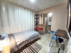 Schlafzimmer mit einem Bett, einem Tisch und einem Schreibtisch in der Unterkunft Costa Rica Eco-Container Hotel in Alajuelita