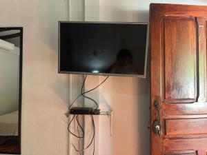 TV de pantalla plana colgada en la pared en Cabinas Bahía Uvita - Marino Ballena National Park Lodge, en Uvita