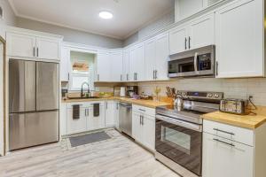 uma cozinha com armários brancos e electrodomésticos de aço inoxidável em Stylish Home with Pool, 5 Mi to Bryant-Denny Stadium em Tuscaloosa