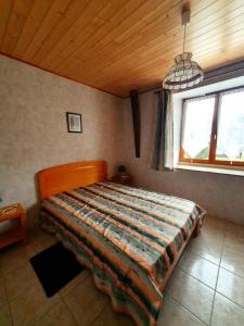 a bedroom with a bed in a room with a window at Gîte de France La barthèçoice 3 épis - Gîte de France 7 personnes MAE-0074 in Tarnac