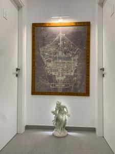 une statue devant un mur avec une peinture dans l'établissement Ecclesia Domus Vatican Inn, à Rome