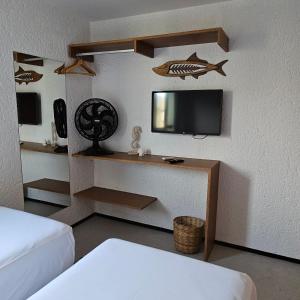 Cette chambre comprend un lit et une télévision murale. dans l'établissement Apto relaxante próximo a Praia do Patacho CVPE102, à Porto de Pedras