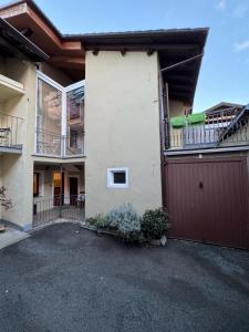 ein Apartmenthaus mit einer Garage und einem Zaun in der Unterkunft La Casa di Vitto in Boves