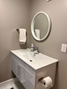 a bathroom with a white sink and a mirror at Niagara Getaway across Fallsview in Niagara Falls