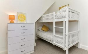 a bedroom with a white bunk bed and a white dresser at Heatherslade House - Hot Tub, Dog Friendly in Parkmill +32 photos
