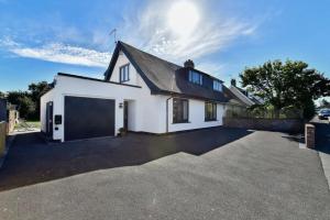 a white house with a garage at Heatherslade House - Hot Tub, Dog Friendly in Parkmill