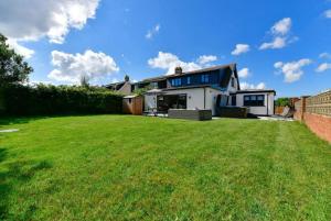 a large lawn in front of a house at Heatherslade House - Hot Tub, Dog Friendly in Parkmill