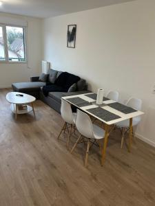 een woonkamer met een tafel en een bank bij 2 bedrooms proche Paris/CDG/Bourget/Parc des expo in Le Blanc-Mesnil