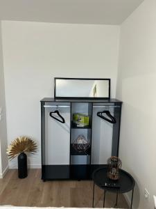 een zwart-witte koelkast in een kamer met een tafel bij 2 bedrooms proche Paris/CDG/Bourget/Parc des expo in Le Blanc-Mesnil