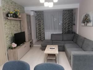 a living room with a couch and a table at Apartament Confortabil, Luminos in Galaţi