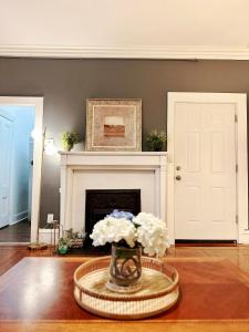 a living room with a fireplace and a vase of flowers at Cozy 2B1B Home ｜Walk to BROWN｜RISD｜Pet friendly in Providence