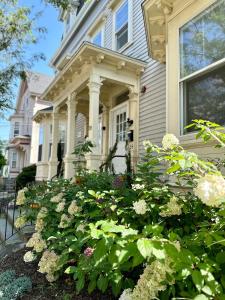 a house with a bunch of flowers in front of it at Cozy 2B1B Home ｜Walk to BROWN｜RISD｜Pet friendly in Providence