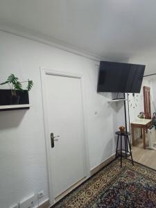 een witte deur met een flatscreen-tv aan een muur bij Apartamento en el casco viejo de Castro Urdiales in Castro-Urdiales