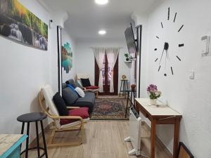 een woonkamer met een bank en een klok aan de muur bij Apartamento en el casco viejo de Castro Urdiales in Castro-Urdiales