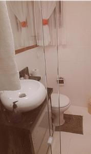 een badkamer met een witte wastafel en een toilet bij Apartamento compartilhado quarto privativo in Foz do Iguaçu