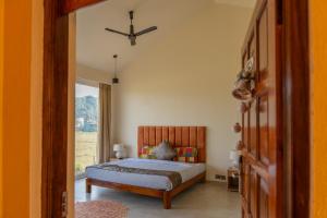 Schlafzimmer mit einem Bett und einem Fenster in der Unterkunft La Luxo in Anjuna