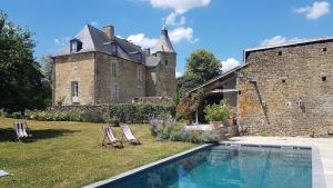 uma casa com piscina em frente a um edifício em L'annexe du Plessis Bochard em Saint-Pierre-des-Nids