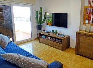 a living room with a couch and a flat screen tv at Piso en Candelaria con terraza, vistas al mar, aire acondicionado y garaje in Candelaria