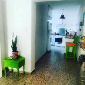 a kitchen with a green table and a refrigerator at CasitaLibertad 
