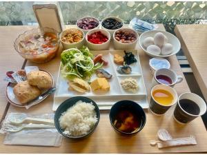 une table recouverte de assiettes et de bols de nourriture dans l'établissement Hotel Tetora Makuhari Inagekaigan - Vacation STAY 91516v, à Chiba