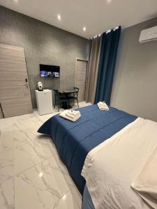 Un dormitorio con una cama azul y una mesa en Fly Home, en Nápoles