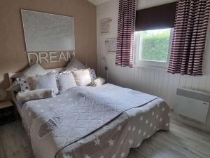 a bedroom with a bed with a blue comforter and a window at Holiday home Amelie Comfortable Vacation Home in Sieseby