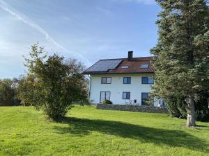 a large white house in a field with trees at Appealing apartment near lake in Argenbühl