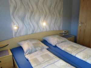 twee bedden in een kleine kamer met een muur met beluchting bij Holiday apartment dream view in Kleinern
