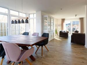 a living room with a wooden table and chairs at Beach House Langeoog in Langeoog