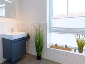 a bathroom with a sink and a window at Beach House Langeoog in Langeoog