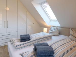 two beds in a attic bedroom with a skylight at Beach House Langeoog in Langeoog