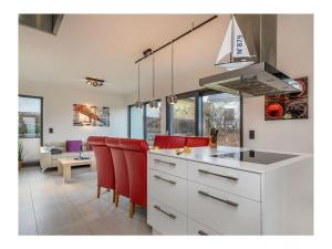 una cucina con sedie rosse e piano di lavoro bianco di Holiday Apartment 1 a Juliusruh