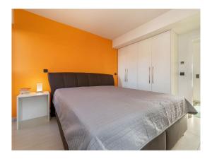 una camera con un grande letto e una parete arancione di Holiday Apartment 1 a Juliusruh