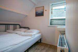 een kleine slaapkamer met een bed en een raam bij Carpe Diem Egmond aan Zee by Urban Home Stay in Egmond aan Zee