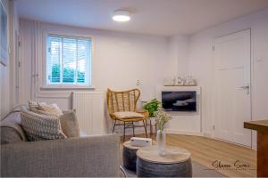 a living room with a couch and a tv at Carpe Diem Egmond aan Zee by Urban Home Stay in Egmond aan Zee