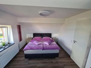 1 dormitorio con 1 cama con edredón morado en Holiday oasis mints en Cuxhaven
