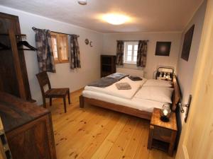 um quarto com uma cama e piso em madeira em Holiday home Goßdorf em Hohnstein